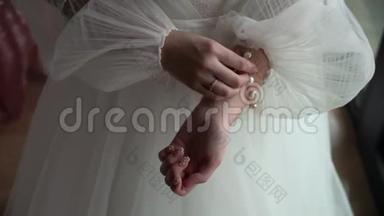 新娘在婚纱上系扣子。 穿上婚纱，穿礼服